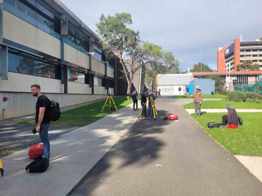 Students participating in practical surveying training in Melbourne using total stations and field survey equipment