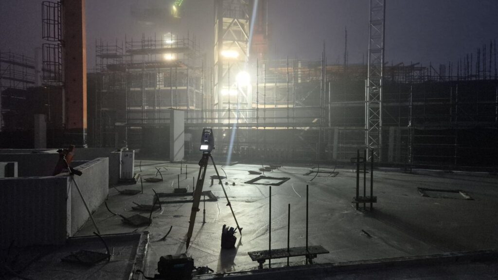 Total station on tripod operating in heavy fog on a Melbourne construction site at night