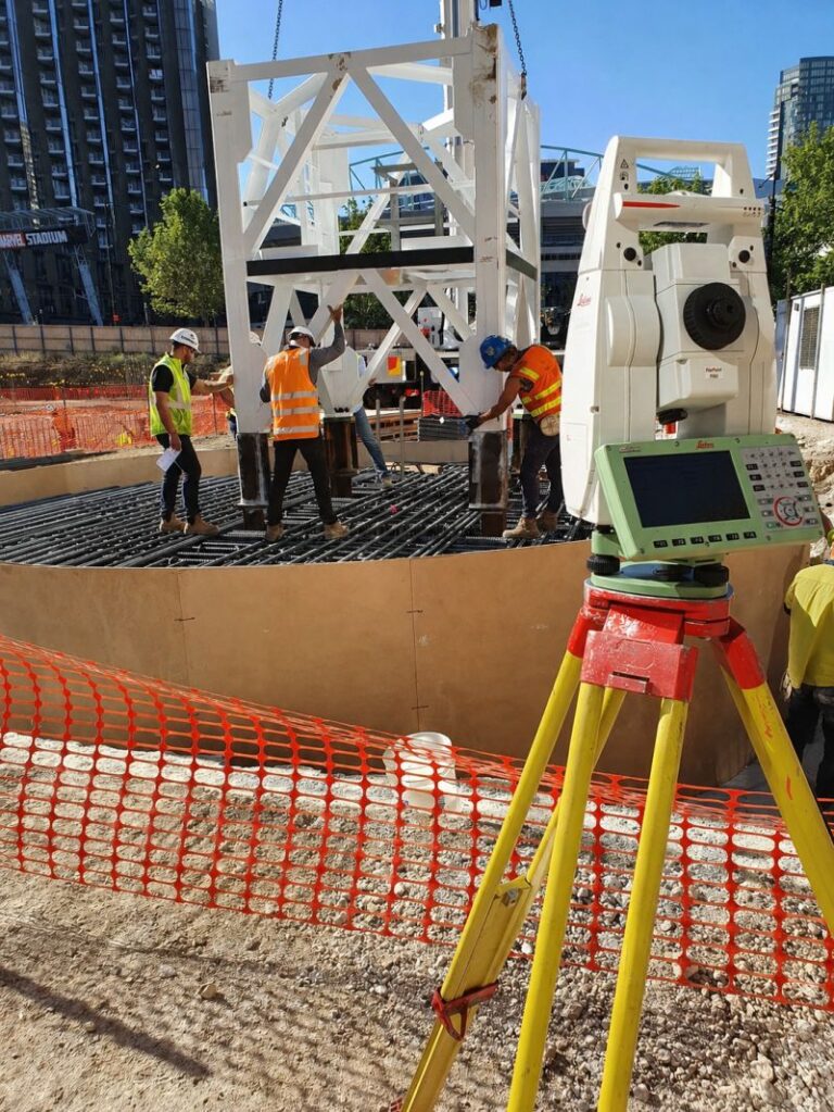 Surveying tribrach mounted on an improvised flat steel plate fixed to a concrete slab on a construction site